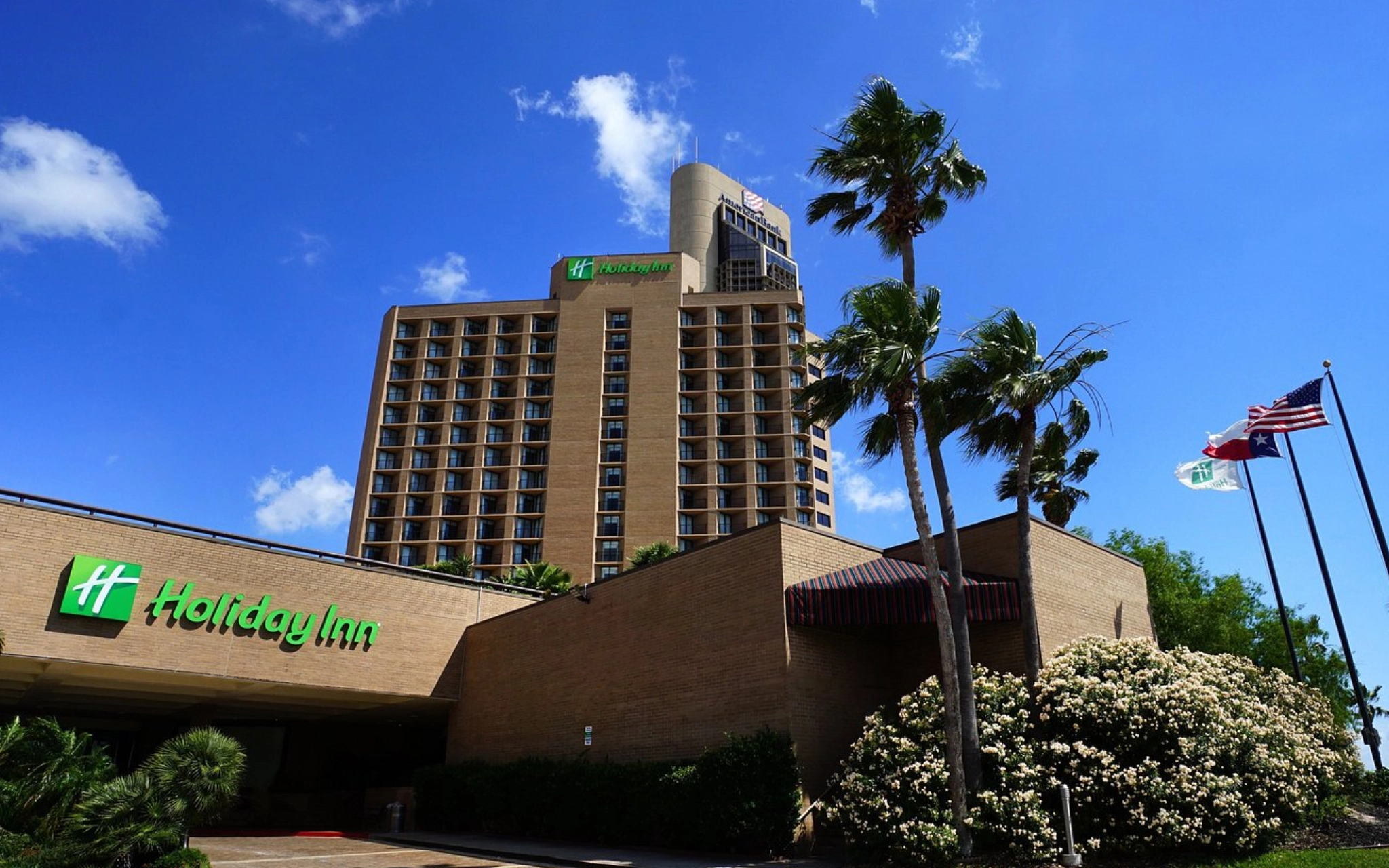 Holiday Inn hotel with palm trees outside.