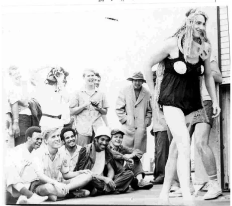 Man in costume entertaining a seated crowd.