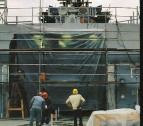 Workers inspecting scaffolding on construction site.
