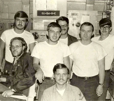 Group of men in a vintage control room.